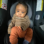 Anthony joined the competition — help win amazing prizes! baby, child, car_seat, infant, clothing, socks, striped, brown, orange, seat, safety, warning_label, indoor, portrait, cute, person, young_child, comfortable, looking, closeup