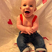 Luka joined the competition — help win amazing prizes! baby, smiling, suspenders, jeans, barefoot, heart, red, cute, happy, infant, child, sitting, portrait, indoor, fabric, background, cute_expression, playful, skin, childhood