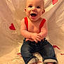 baby, smiling, suspenders, jeans, barefoot, heart, red, cute, happy, infant, child, sitting, portrait, indoor, fabric, background, cute_expression, playful, skin, childhood