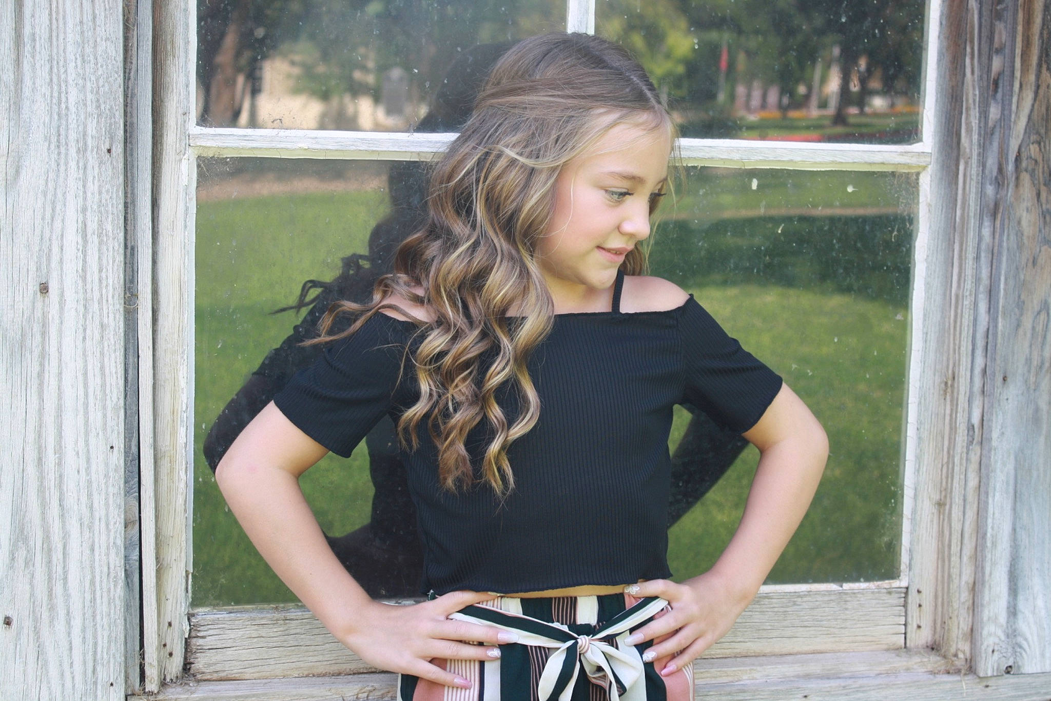 Brinlee is registered to the contest to win money with this photo: denim, eyewear, grass, jewellery, joint, knee, long_hair, neck, person, plaid, plant, shoulder, sleeve, standing, t_shirt, tartan, thigh, tree, trunk, waist