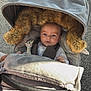 Louka participe au concours pour gagner de l'argent avec cette photo : baby, blanket, child, comfort, cushion, expression, fabric, face, fur_hood, giraffe, infant, nature, outdoor, person, seatbelt, stroller, sunlight, toy, warm_clothing, wheels