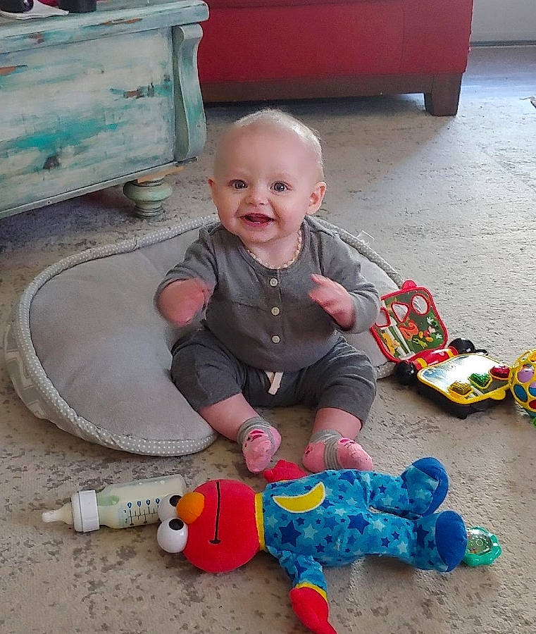Mya-lee is registered to the contest to win money with this photo: automotive_exterior, baby, baby_playing_with_toys, baby_products, baby_toddler_clothing, baby_toys, child, flooring, fun, happy, joy, person, plastic, play, product, red, sitting, smile, toddler, toy