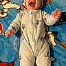 Ezaia is registered to the contest to win money with this photo: baby, infant, smiling, laughing, onesie, mickey_mouse, blanket, blue, lying_down, happy, cute, child, clothing, cartoon, disney, soft, indoors, face, expression, playful