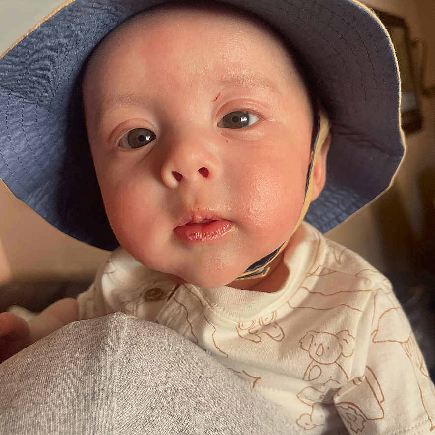Ezaia joined the competition — help win amazing prizes! baby, child, face, hat, blue_hat, indoor, person, skin, eyebrows, eyes, clothing, infant, curious, portrait, headwear, closeup, young, cute, cheeks, expression