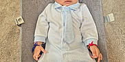 Keeton is registered to the contest to win money with this photo: baby, infant, onesie, tie, baby_seat, carpet, bracelet, blue, white, striped, cute, child, portrait, laying_down, indoors, clothing, footed_pajamas, small_hands, curious, young
