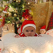 Alexander is registered to the contest to win money with this photo: baby, christmas, holiday, santa_hat, plush, snowman, tree, decorations, lights, festive, blanket, indoors, cute, red, white, face, toy, seasonal, smile, child