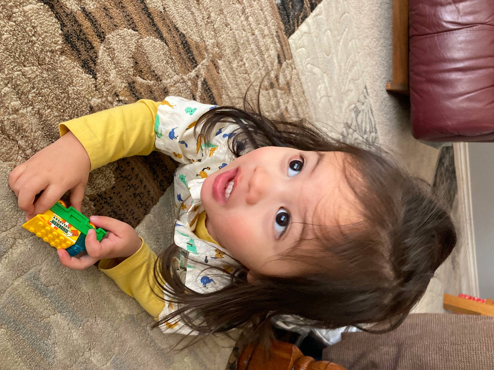 Felix is registered to the contest to win money with this photo: baby, baby_toddler_clothing, cheek, child, flooring, fun, happy, person, pillow, room, sitting, skin, surprise, toddler, toy, vacation, wood