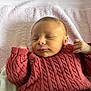 baby, newborn, sleeping, red_sweater, knitwear, hands, towel, pink, soft_texture, cozy, infant, portrait, resting, peaceful, cute, closeup, child, warmth, skin, face