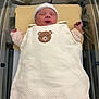 newborn, baby, sleeping, bassinet, hospital, blanket, white, hat, cute, teddy_bear, clothing, infant, peaceful, resting, swaddled, pink_sweater, soft, indoors, person, newborn_baby