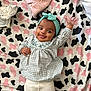 Carolina is registered to the contest to win money with this photo: baby, infant, child, headband, smiling, waving, lying_down, blanket, pattern, pink, black, white, clothing, cute, happy, indoors, portrait, gown, toddler, cheerful