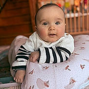 Alix a rejoint le concours — aidez-le/la à gagner de superbes lots ! baby, infant, child, face, eyes, sweater, striped_clothing, pillow, patterned_pillow, hand, arm, soft_lighting, indoors, wooden_stairs, crib, blurred_background, cozy, cute, portrait, lying_down