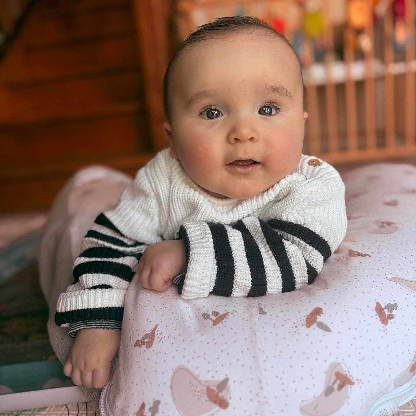Alix a rejoint le concours — aidez-le/la à gagner de superbes lots ! arm, baby, blurred_background, child, cozy, crib, cute, eyes, face, hand, indoors, infant, lying_down, patterned_pillow, pillow, portrait, soft_lighting, striped_clothing, sweater, wooden_stairs
