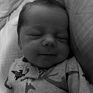 Colton joined the competition — help win amazing prizes! baby, sleeping, infant, face, hair, onesie, dinosaur_pattern, cozy, bed, pillow, blanket, cute, peaceful, newborn, portrait, child, soft_lighting, monochrome, closeup, resting
