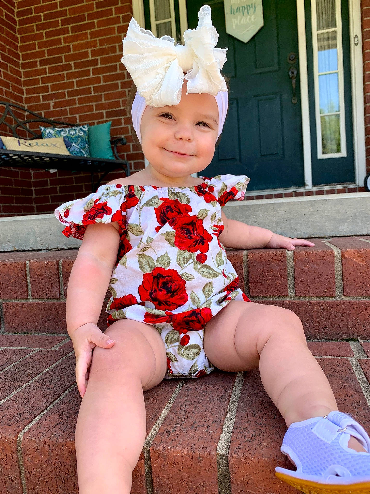 Hensley is registered to the contest to win money with this photo: baby_toddler_clothing, brick, costume_hat, door, face, fun, happy, headgear, headwear, human_leg, joy, knee, lap, leg, pattern, person, pink, sleeve, smile, sock