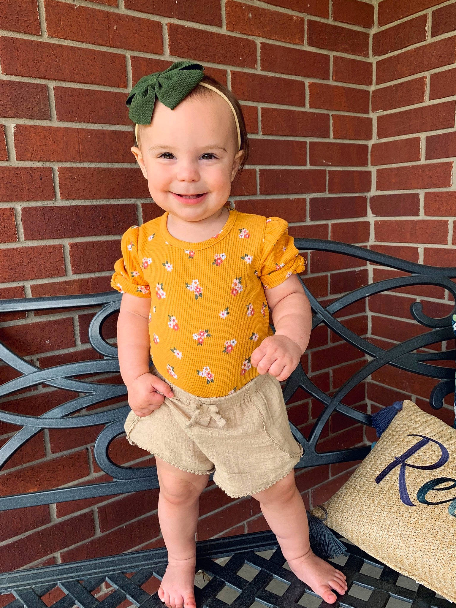 Hensley is registered to the contest to win money with this photo: baby_toddler_clothing, barefoot, brick, chin, cool, facial_expression, hairstyle, happy, joy, leg, orange, pattern, person, pink, shorts, sleeve, smile, summer, t_shirt, textile