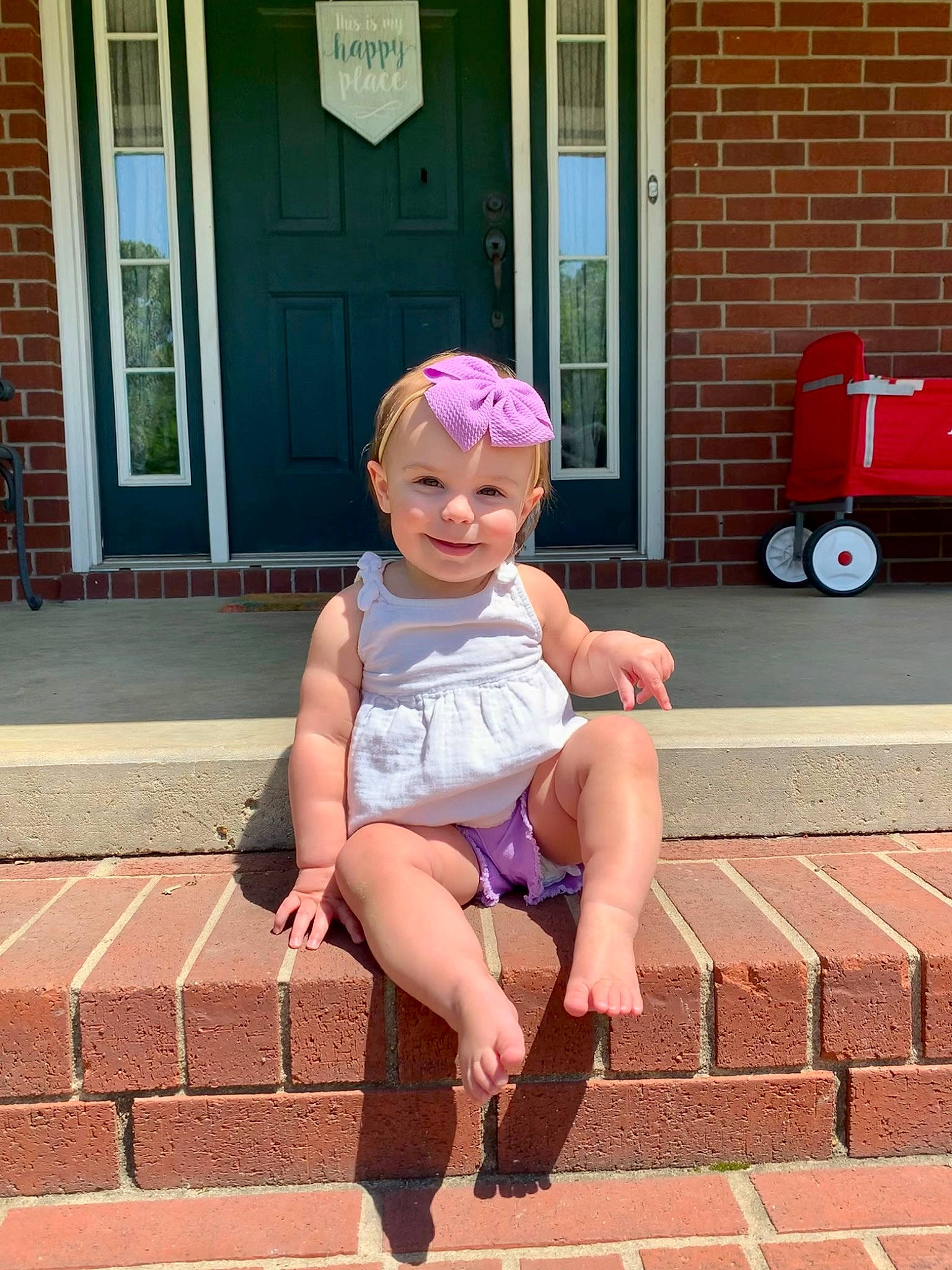 Hensley is registered to the contest to win money with this photo: baby_toddler_clothing, cap, door, foot, happy, hat, headwear, joint, joy, knee, leisure, magenta, person, pink, sandal, sidewalk, sock, standing, summer, thigh