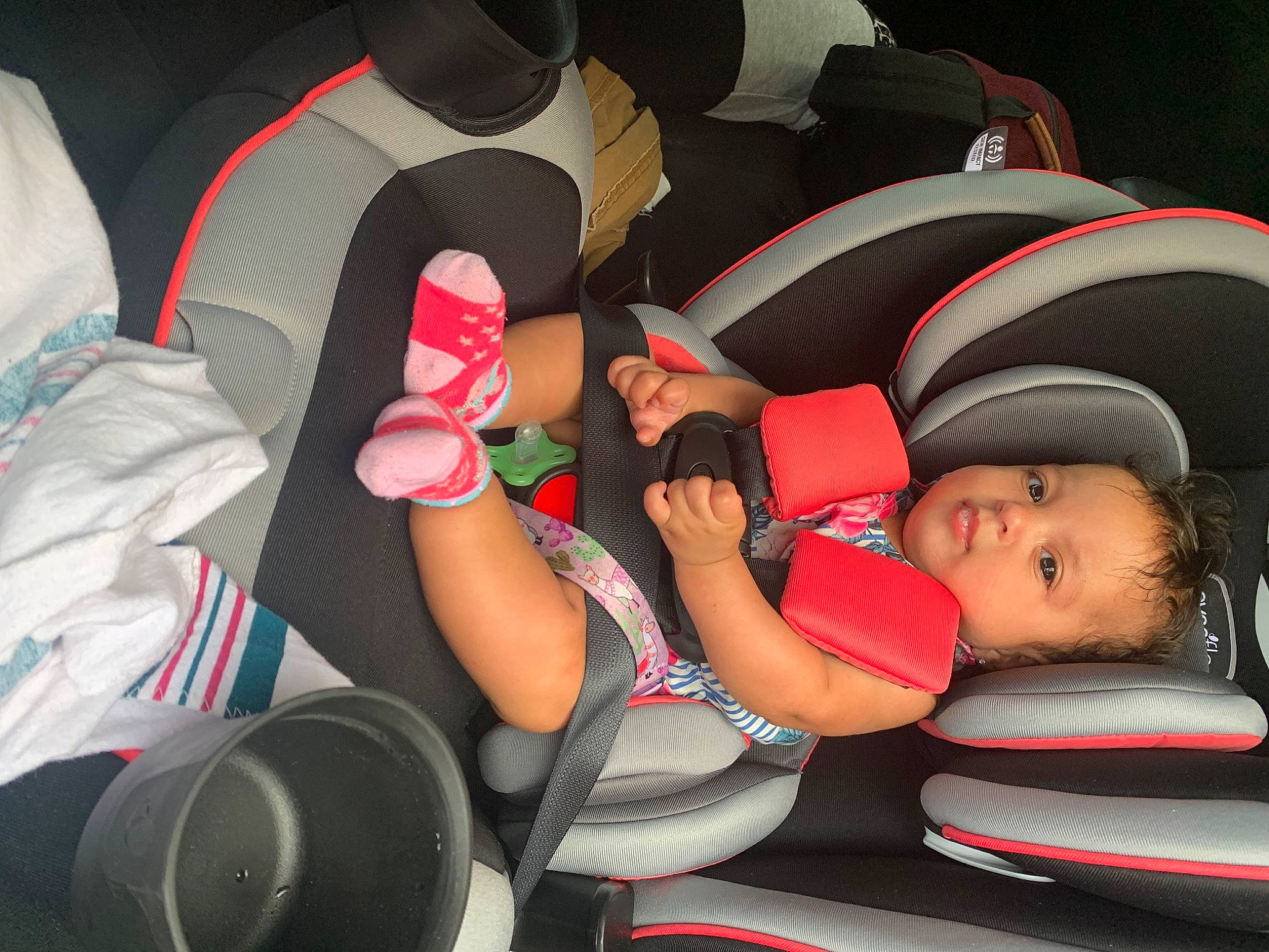 Samaya is registered to the contest to win money with this photo: auto_part, automotive_design, baby, car_seat, child, comfort, finger, fun, hat, headgear, human_body, knee, lap, leg, mammal, mouth, people, person, product, thigh