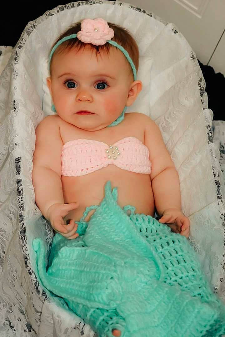 Adilynn is registered to the contest to win money with this photo: aqua, baby, baby_products, cheek, child, dress, eye, face, hair_accessory, head, headgear, iris, lip, person, pink, product, skin, textile, toddler, turquoise