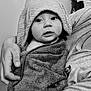 arm, baby, black_and_white, blanket, caring, child, curious, eyes, fabric, face, hand, holding, hood, indoor, mouth, person, portrait, skin, texture, towel