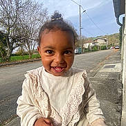 Liana participe au concours pour gagner de l'argent avec cette photo : toddler, child, smiling, outdoor, street, sweater, lace, happy, person, portrait, daylight, trees, sidewalk, curb, clothing, cute, young_child, face, eyes, hand