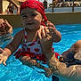 adult_hand, blue_sky, child, family, fun, happy, outdoor, palm_tree, people, pool, red_bandana, smiling, summer, sunlight, sunny, swimming, swimsuit, toddler, vacation, water