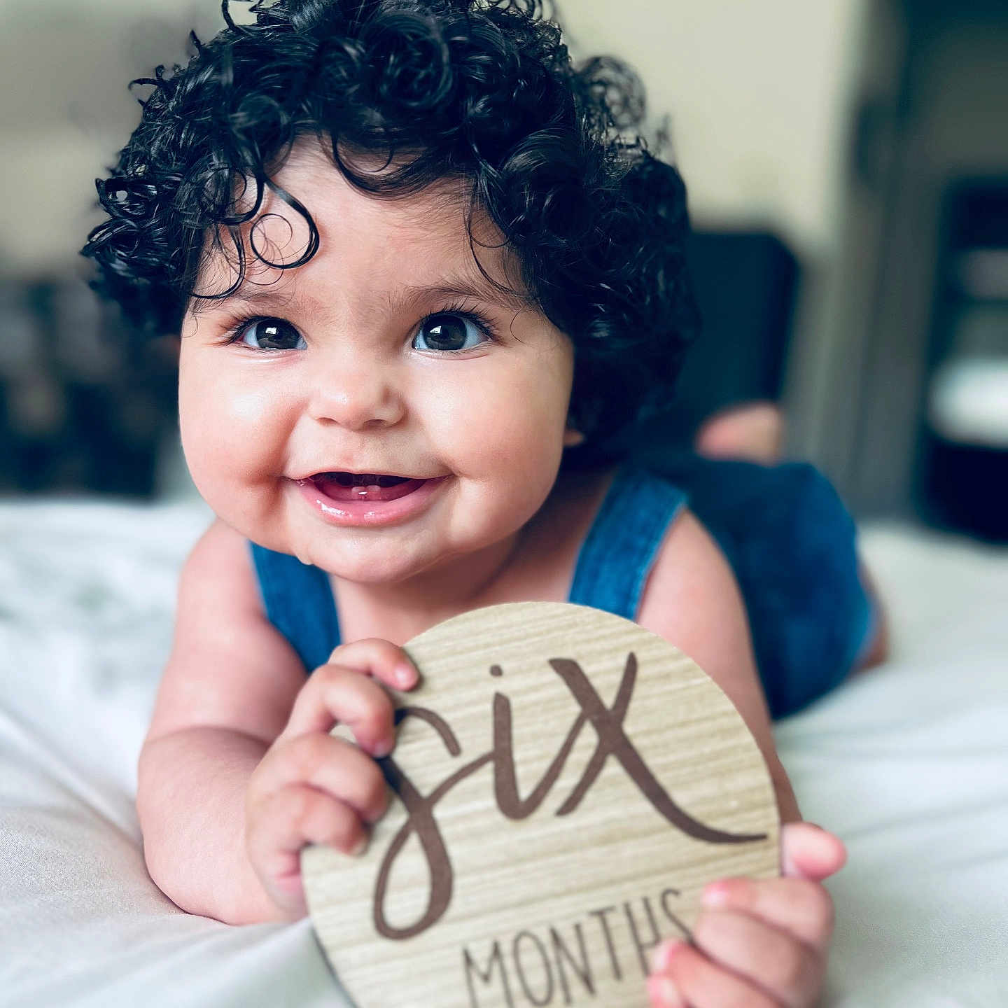 Amelia is registered to the contest to win money with this photo: baby, bed, bedroom, bodypart, clothing, dress, face, finger, furniture, hair, hand, happy, head, indoors, laughing, person, photography, portrait, room, smile