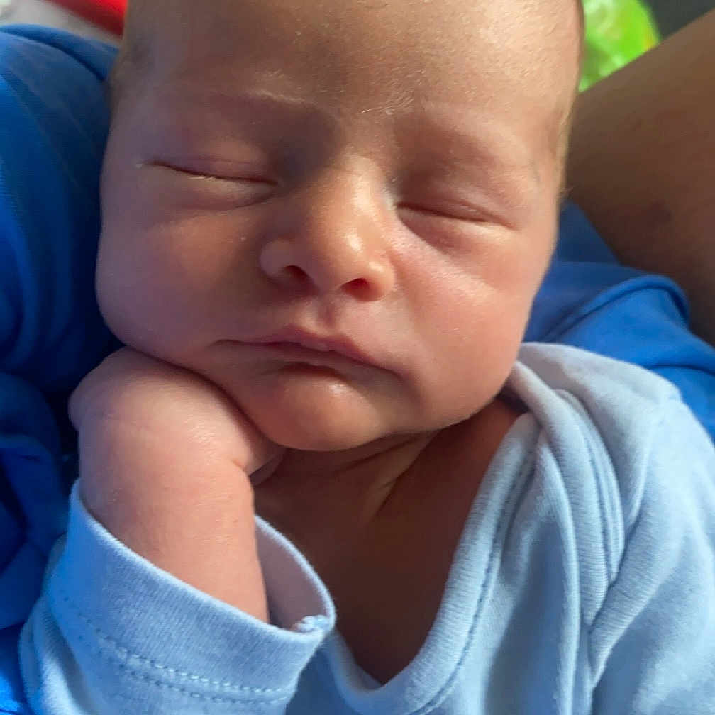 Noah is registered to the contest to win money with this photo: architecture, baby, bodypart, building, clothing, cushion, face, finger, frown, glove, hand, head, homedecor, hospital, newborn, person, photography, portrait, sad, sleeping
