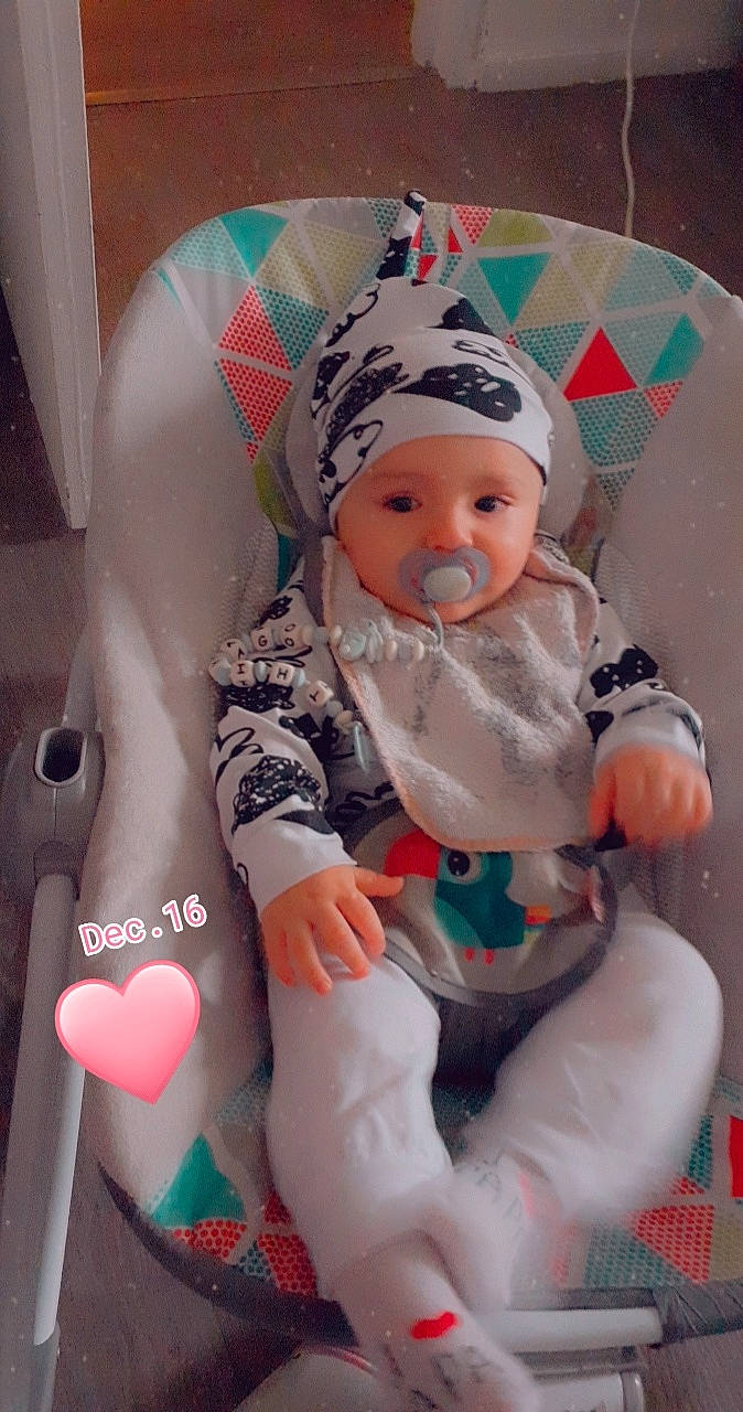 Thiyago a rejoint le concours — aidez-le/la à gagner de superbes lots ! art, baby, baby_products, baby_toddler_clothing, cap, chair, cheek, child, comfort, face, fun, headwear, human_body, lap, person, personal_protective_equipment, pink, sitting, skin, sock