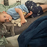 Mélyohann participe au concours pour gagner de l'argent avec cette photo : child, toddler, pacifier, stuffed_animal, cat, grey_cat, sofa, blanket, pillow, pajamas, blue_shirt, lying_down, pet, indoor, cozy, cuddling, plush_toy, home, relaxing, portrait