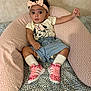 Maya participe au concours pour gagner de l'argent avec cette photo : baby, child, headband, pink, sneakers, socks, denim_shorts, tshirt, minnie_mouse, cushion, patterned_background, curious_expression, indoor, seated, person, footwear, clothing, soft_furniture, infant, cute
