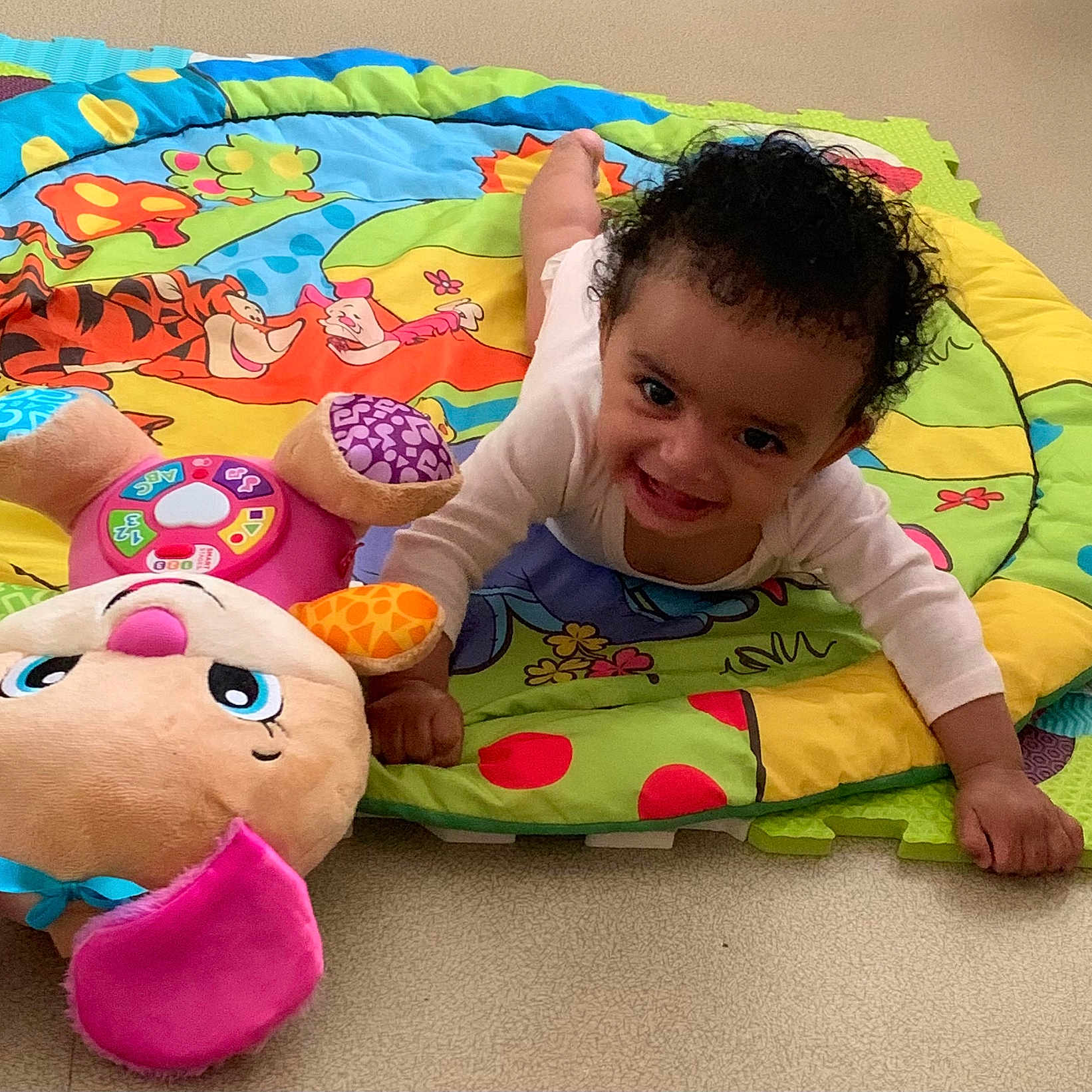 Maya participe au concours pour gagner de l'argent avec cette photo : baby, blue, bright, child, colorful, crawling, curly_hair, cute, floor, green, happy, indoor, infant, person, pink, play_mat, plush_toy, smiling, soft_toy, toy
