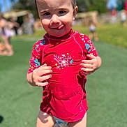 Inaya a rejoint le concours — aidez-le/la à gagner de superbes lots ! barefoot, child, cute, daylight, fun, grass, happy, outdoor, person, play, playground, red_shirt, smiling, summer, sunny, swimwear, toddler, tongue_out, water_play, young_child