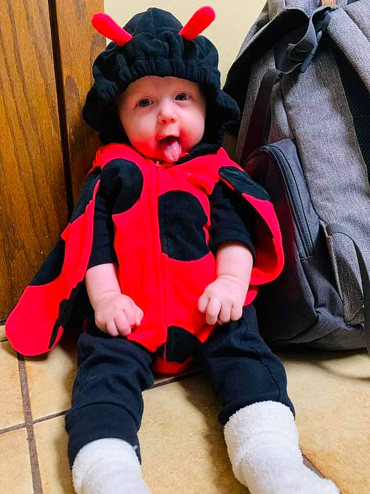 Hadley is registered to the contest to win money with this photo: baby, baby_toddler_clothing, cap, cheek, child, comfort, costume_hat, eye, face, flooring, headgear, headwear, outerwear, person, pink, red, shoe, skin, sleeve, textile