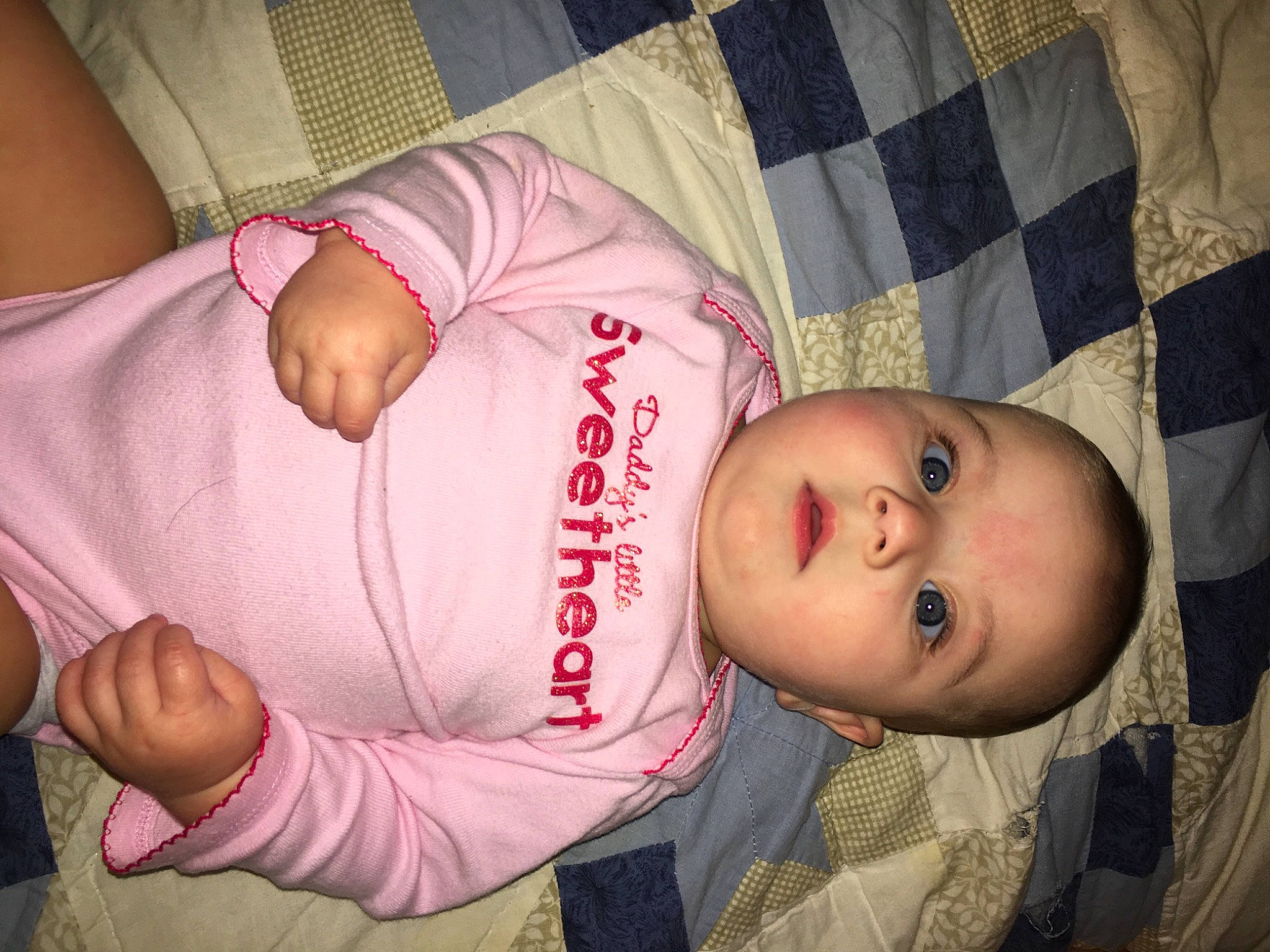 Oaklynn is registered to the contest to win money with this photo: abdomen, baby, baby_products, baby_toddler_clothing, cheek, child, comfort, elbow, finger, linens, mammal, mouth, nose, pattern, person, room, sitting, skin, sleeve, toddler