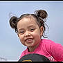 child, girl, smiling, happy, face, hair_buns, pink_shirt, outdoor, sky, portrait, cute, young, childhood, joy, innocence, person, head, casual_clothing, daylight, cheerful