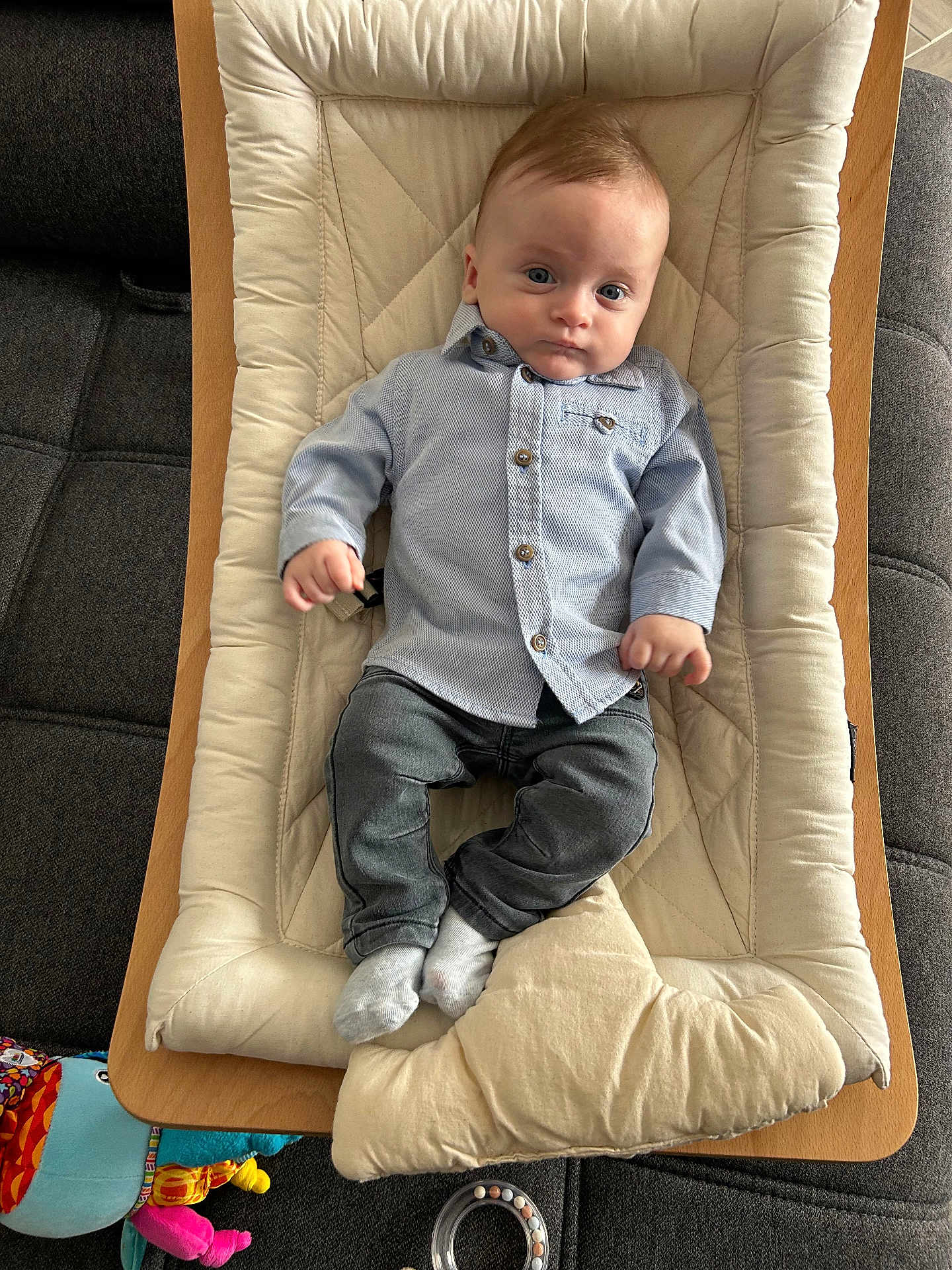 Adam a rejoint le concours — aidez-le/la à gagner de superbes lots ! baby, infant, child, blue_shirt, jeans, socks, baby_bouncer, cushion, sofa, toy, indoor, portrait, casual_clothing, baby_seat, wooden_frame, relaxed, young_child, face, person, comfort