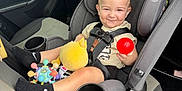 Leon joined the competition — help win amazing prizes! toddler, child, car_seat, toy, plush_toy, red_ball, car_interior, seatbelt, smile, clothing, sock, nike, window, door, cup_holder, graco, seat, person, sun_emoji, vehicle
