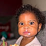 Londyn is registered to the contest to win money with this photo: toddler, child, face, milk, food, cake, spoon, messy, curly_hair, indoor, couch, clothing, expression, closeup, person, portrait, young_child, sitting, eye_contact, casual