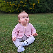 Milana participe au concours pour gagner de l'argent avec cette photo : baby, child, grass, outdoor, pink_cardigan, leggings, socks, sitting, greenery, nature, portrait, curious, cute, young_child, soft_background, yellow_flowers, blurry_background, daylight, face, person