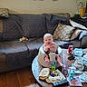 Elijah joined the competition — help win amazing prizes! baby, baby_seat, blanket, can, candle, coffee_table, diaper, hair_brush, happy, headphones, indoor, living_room, person, pillow, remote_control, smiling, sofa, toy, wall_decal, wood_floor