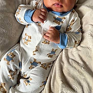 Ashton joined the competition — help win amazing prizes! baby, infant, blanket, onesie, hat, cute, sleepwear, child, portrait, lying_down, soft_texture, indoor, cozy, toddler, small_hands, adorable, face, sleeping_area, warm, plush