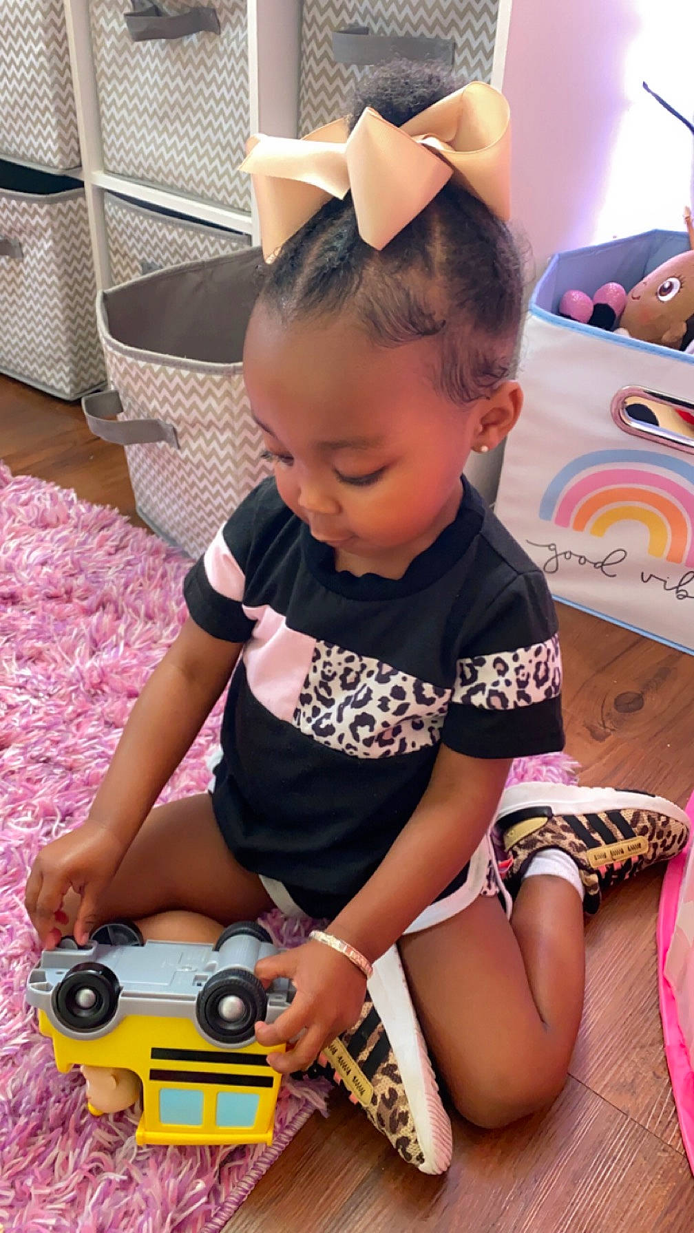 Karleigh is registered to the contest to win money with this photo: arm, baby, baby_toddler_clothing, camera, chair, child, facial_expression, fun, hairstyle, hand, happy, pattern, person, pink, play, sitting, sleeve, t_shirt, thigh, toddler