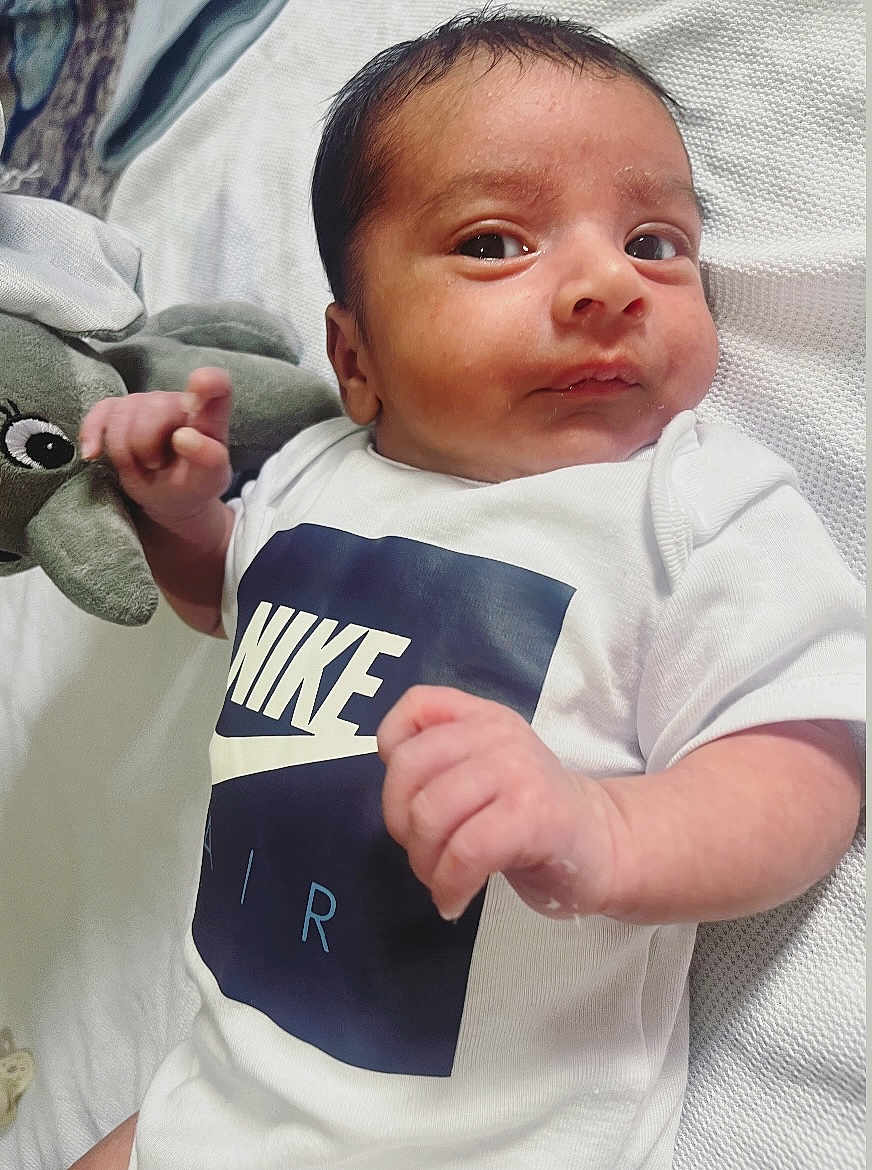Reyansh is registered to the contest to win money with this photo: baby, blanket, child, closeup, cute, elephant_toy, expression, eyes, fabric, face, hand, indoors, infant, lying_down, newborn, nike_logo, plush_toy, skin, texture, white_onesie