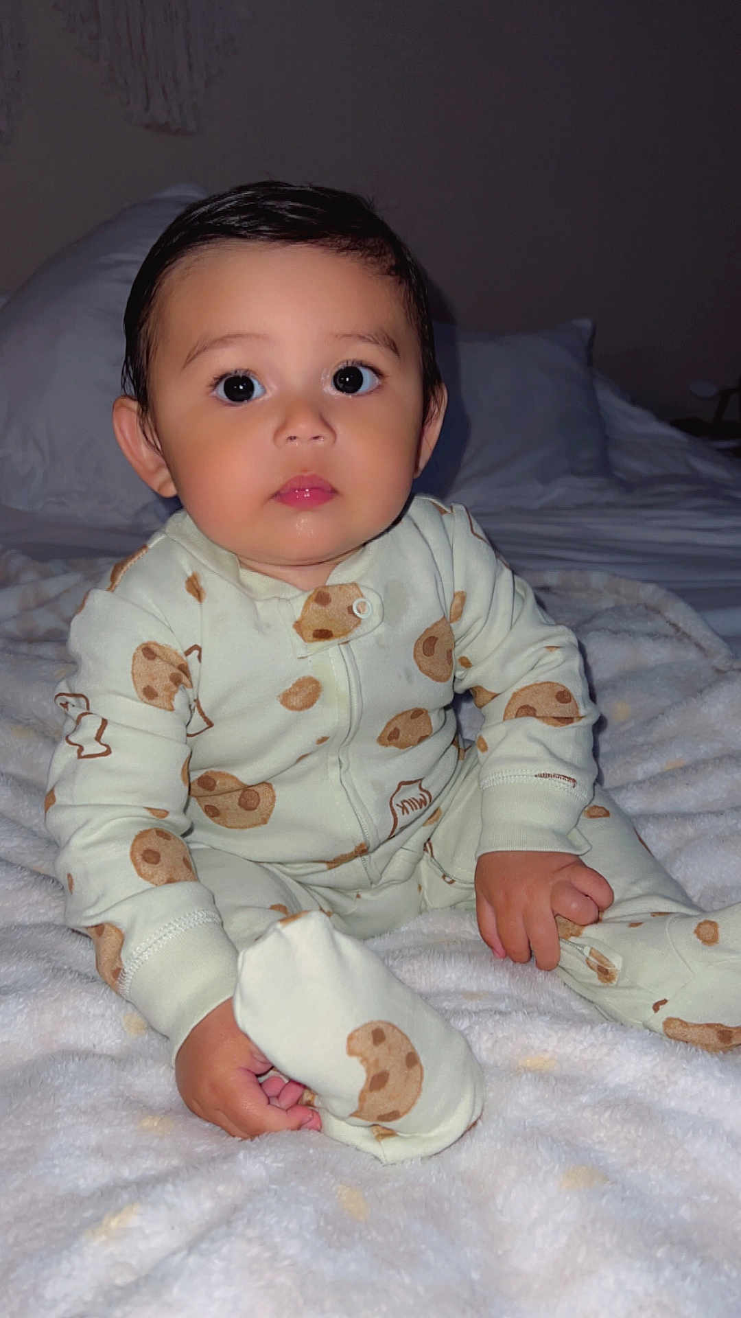 River joined the competition — help win amazing prizes! baby, child, pajamas, cookie_pattern, blanket, bed, indoor, cute, portrait, young_child, sitting, person, infant, face, hand, foot, sleepwear, soft_texture, cozy, looking