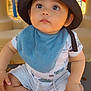baby, child, hat, bucket_hat, blue_bib, playground, outdoor, cute, infant, sitting, curious, clothing, shorts, person, face, legs, barefoot, summer, daylight, expression
