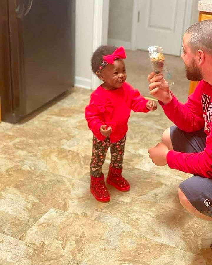 Blessings is registered to the contest to win money with this photo: baby, cabinetry, child, cupboard, event, flooring, fun, gesture, happy, hardwood, hat, headwear, leisure, person, plastic_bottle, play, room, t_shirt, thigh, thumb