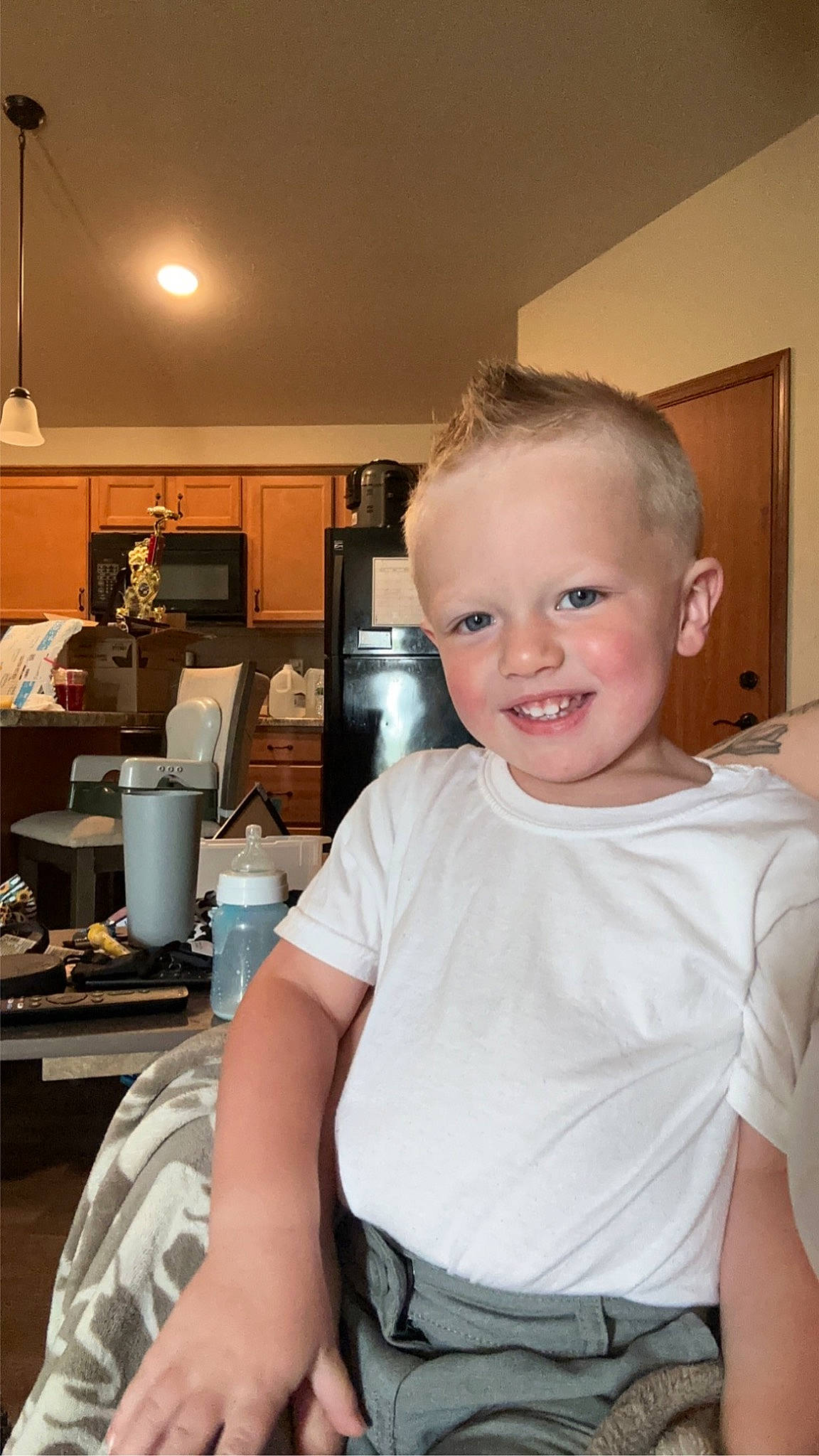 Grayson is registered to the contest to win money with this photo: belt, cabinetry, chair, chest, cooking, countertop, flooring, happy, home_appliance, homemaker, jewellery, joy, kitchen, kitchen_appliance, lamp, major_appliance, person, refrigerator, room, shoulder