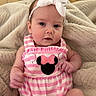 baby, infant, headband, bow, pink_stripes, mickey_mouse, clothing, blanket, wooden_floor, cute, child, portrait, sitting, indoors, soft_texture, relaxed, young, small, person, adorable
