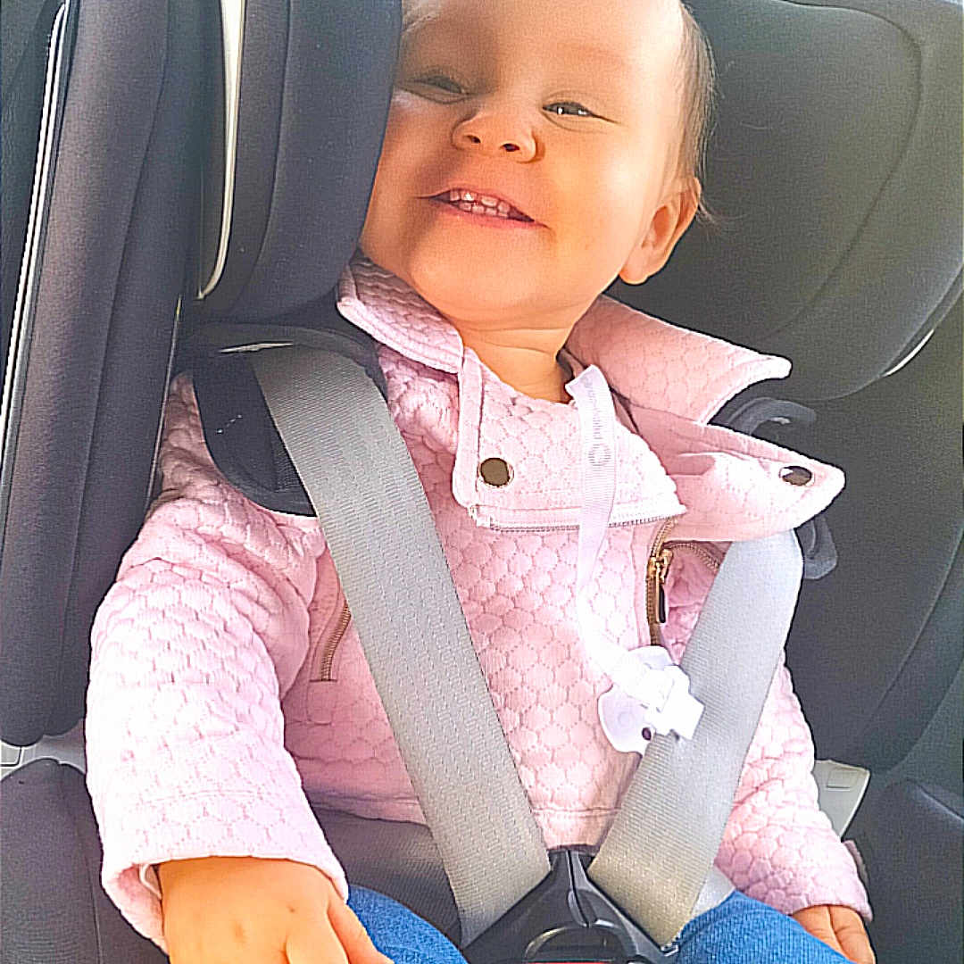 Léna a rejoint le concours — aidez-le/la à gagner de superbes lots ! accessories, baby, belt, car, car_interior, carseat, clothing, cushion, face, head, homedecor, jeans, pants, person, photography, portrait, seatbelt, sitting, transportation, vehicle