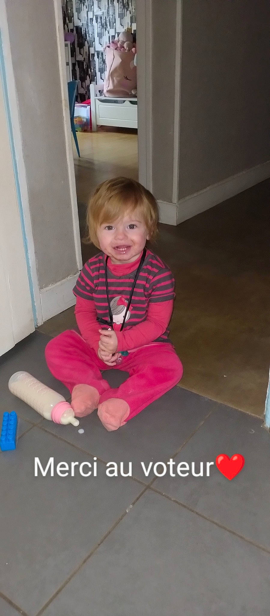 Lilith participe au concours pour gagner de l'argent avec cette photo : baby, baby_toddler_clothing, child, floor, flooring, fun, happy, hardwood, human_leg, joy, knee, magenta, person, play, room, sitting, sleeve, smile, sock, thigh